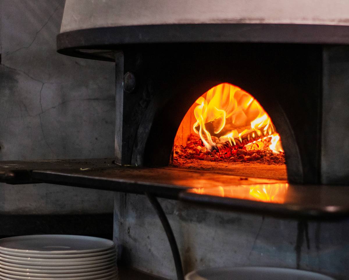 tools for pizza oven showing digital thermometer mounted at oven center with infrared gun nearby
